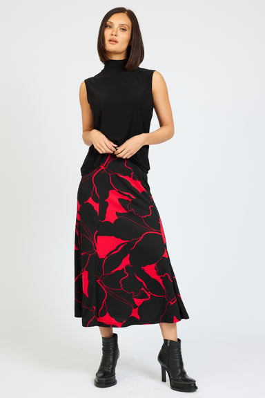 Woman wearing a black sleeveless top and red floral skirt on a white background