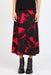 Person wearing a black and red floral patterned skirt with black boots on a white background