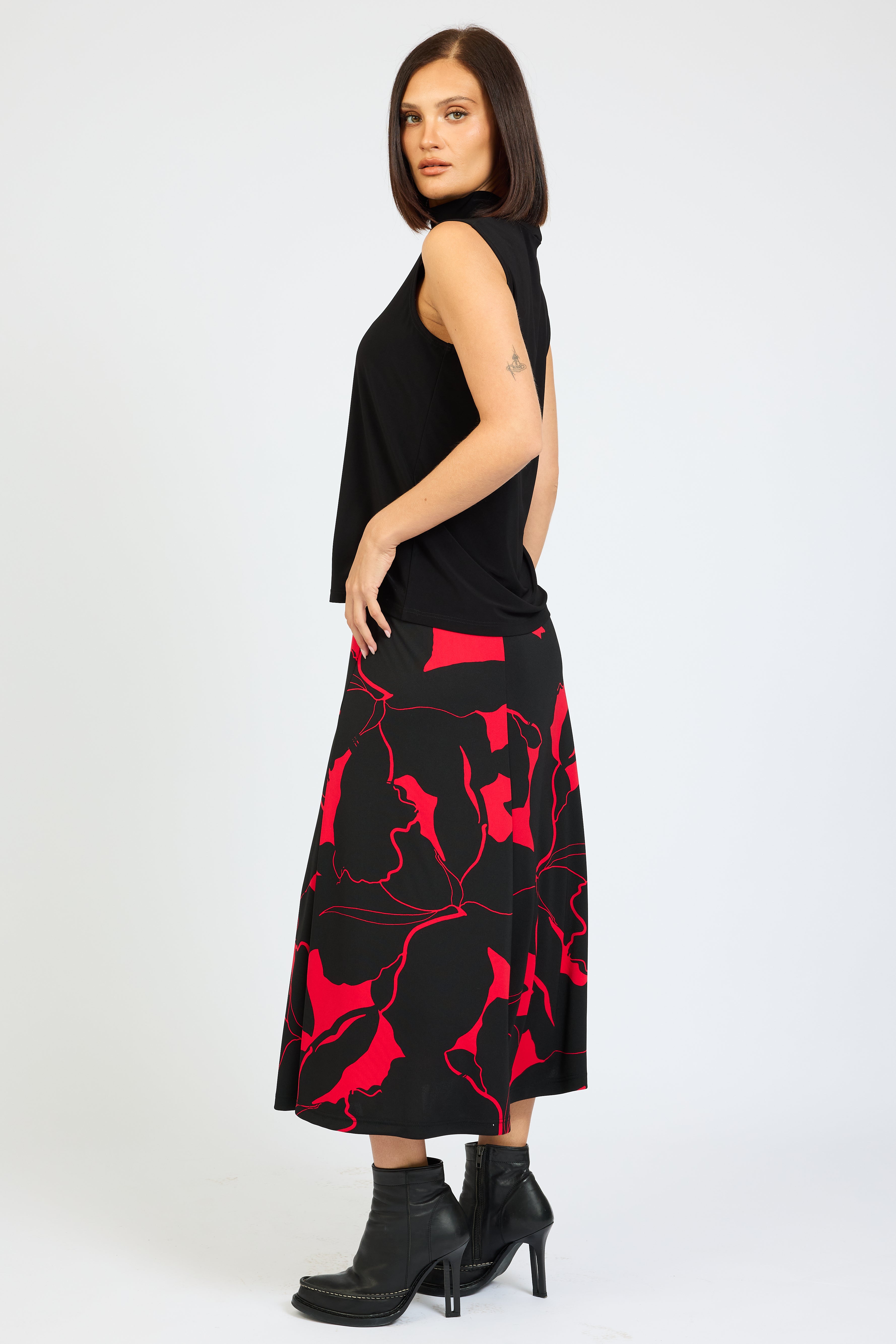 Woman wearing a black dress with red abstract patterns on a white background